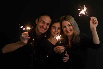 family with sparklers on a black background