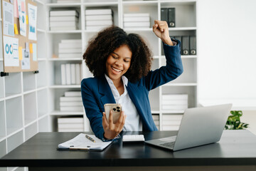 African business woman are delighted and happy with the work they do on their tablet, laptop and taking notes at the office.