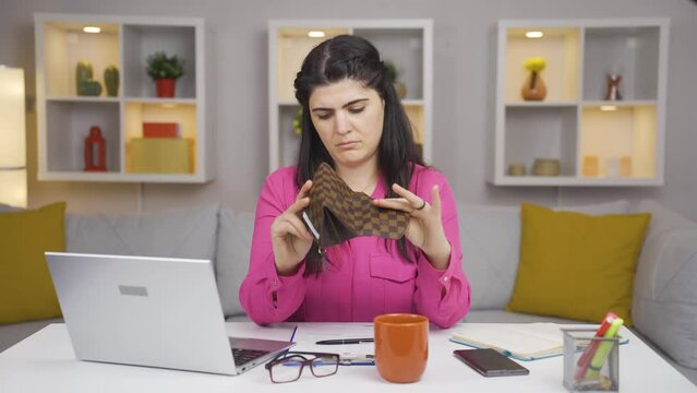Home office worker woman showing her empty wallet to the camera.