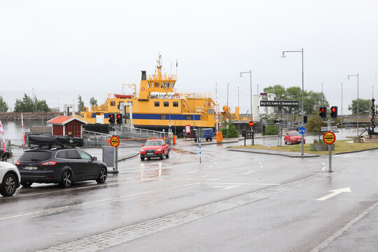 Visingso, Sweden - July 7, 2022: The ferry terminal in the lake Vattern Visings&ouml; harbor with Trafikferket's road ferry Ebba Brahe and waiting cars in rainy weather.