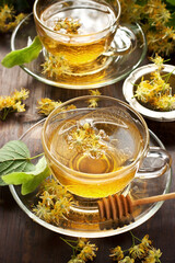 Cup of herbal tea with linden flowers on  old wooden table