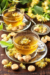 Cup of herbal tea with linden flowers on  old wooden table