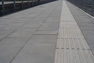 Obraz premium Tactile Paving on Modern Tiles Pathway for Blind Handicap, Safety Sidewalk Walkway for Disability People