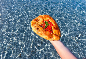 su mustazzeddu, typical Sardinian bread topped with tomato, garlic, basil and onion.