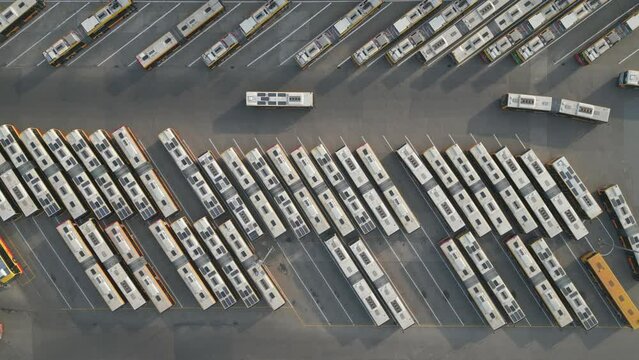 Aerial top down photo of bus terminus, designated place where bus or coach starts or ends its scheduled route termini, buses in parking lot.