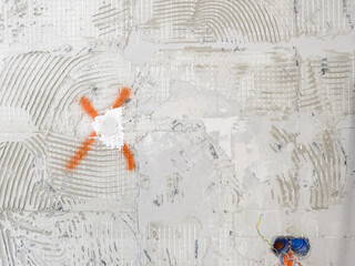 Abstract background of an old wall with fragments of the texture of the adhesive mixture for laying ceramic tiles