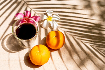 Coffee and Orange under palm shade on the beach.