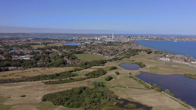 Aerial footage over Gosport and Stokes Bay Golf Course and Gilkicker Lagoon and towards the naval town of Portsmouth.