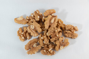 Whole walnuts, a bunch of peeled walnuts on a white background