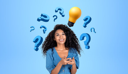 Fototapeta premium Cheerful African woman college student with phone, question marks and light bulb