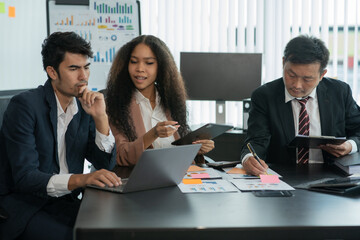 Group of Asian business people stand to talk about the company's project.
