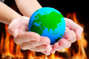 Earth in Flames: Holding a Blue and Green Globe amidst Fiery Background