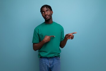 tired young black american man pointing at wall on isolated background
