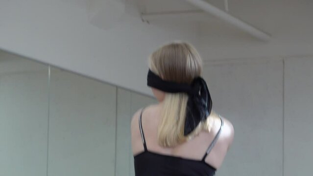 Young lady with black band on her eyes dancing in the Hall. Freedom Conception