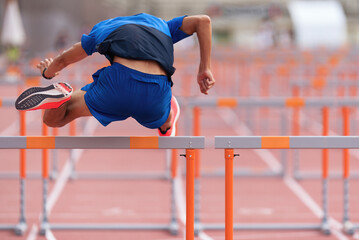 A hurdle runner leaping over the hurdles, man is jumping over the hurdle