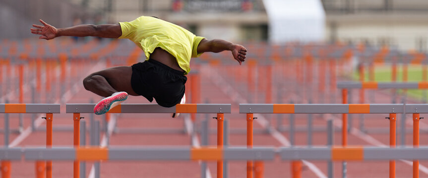 A hurdle runner leaping over the hurdles, man is jumping over the hurdle
