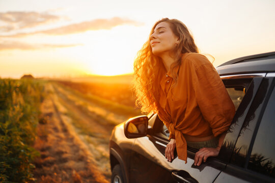 Relaxed happy woman on summer road trip travel in the car. Lifestyle, travel, tourism, nature, active life.