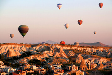 Flight of hot air balloons at dawn over a valley in Cappadocia (Turkey) near the town of Goreme