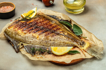 Baked Flounder Fish with lemon and spices on a dark background. banner, menu, recipe place for text, top view