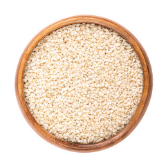 Hulled sesame seeds, white sesame in a wooden bowl. Sesamum indicum, also called benne, with rich and nutty flavor, and with one of the highest oil content of any seed. Isolated, macro food photo.