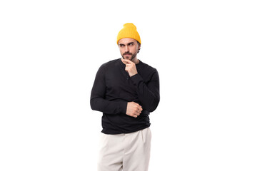 young brutal brunette european brutal man in a black sweatshirt on a white background with copy space