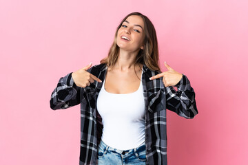 Young Romanian woman isolated on pink background proud and self-satisfied