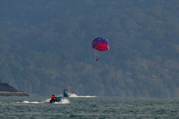 Unidentified people parasailing and ride jet ski at Langkawi Island, malaysia