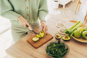 Close up of woman hands cutting fresh avocado in modern kitchen. Nutrition And Diet. Healthy food concept. Ingredients for smoothies