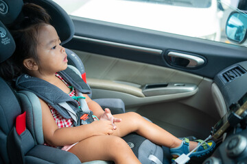 Happy preschool girl sitting on carseat while car travel trip