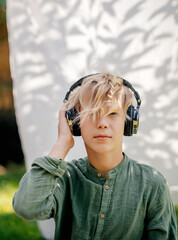 stylish teenager boy listening to music with headphones outdoors. youth movement. adolescence.