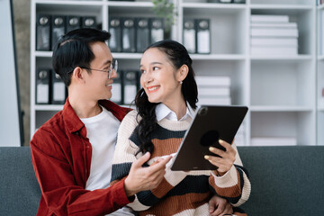 cute cheerful young couple using laptop and analyzing their finances with documents.