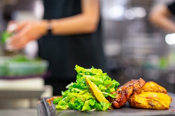 grilled pork neck with baked potatoes and salad on restaurant kitchen