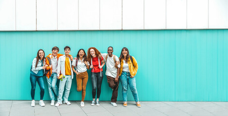 Diverse college students standing together on a blue wall - Photo portrait of multiracial teenagers in front of university building - Life style concept with guys and girls going to highschool - Powered by Adobe