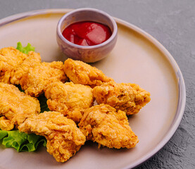 Delicious crispy fried chicken breast strips with tomato sauce