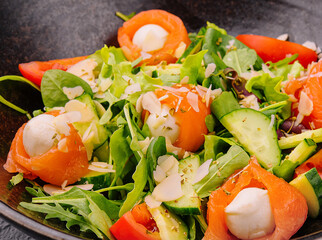 Salmon salad with mozzarella, tomato, cucumber on bowl
