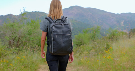 Young woman walks in the mountains and admires the beautiful landscape