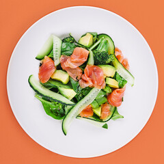 Salmon avocado salad with salted fish, lettuce, broccoli and cucumbers