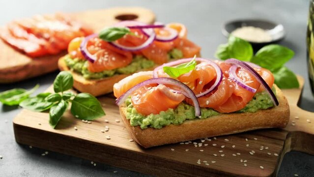 Sandwiches with salted salmon and avocado. Healthy food, appetizer. Video 4k