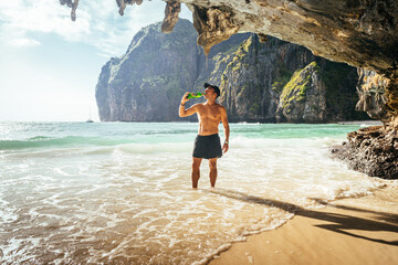 a man is drinking a beer in maya bay beach, thailand