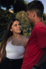 Obraz premium Miradas que desvelan el amor de esta joven y atractiva pareja que disfrutan de un increíble día soleado en el parque.