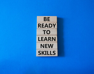 Obraz premium Learn new skills symbol. Concept words Be ready to Learn new skills on wooden blocks. Beautiful blue background. Business and Learn new skills concept. Copy space.