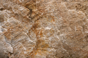Background from a photo of a chipped natural stone of gradient brown color with cracks