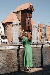 Kobieta w zielonej sukience podziwia Gdańsk - obrazy, fototapety, plakaty