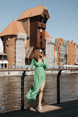 Kobieta w zielonej sukience podziwia Gdańsk - obrazy, fototapety, plakaty