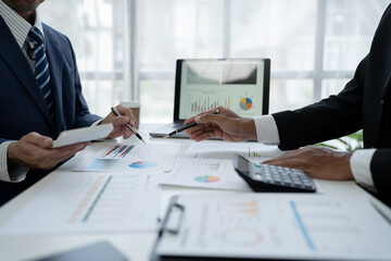 team work process Business team use calculator to calculate figures, business statistics, profit, cost analysis, growth rate graph document. data charts on the desk