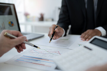team work process Business team use calculator to calculate figures, business statistics, profit, cost analysis, growth rate graph document. data charts on the desk