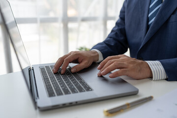 Financial analyst analyzing business financial report on laptop and graph document during discussion in company showing successful teamwork business meeting concept marketing.