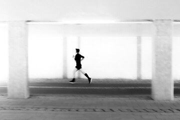 Creative image of silhouette of young person in motion blur jogging