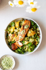 Roast potato and zucchini salad with capers and garlic dressing with mustard salmon
