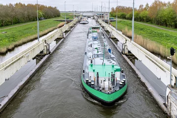 Fotobehang inland  cargo vessel in the Prinses Margrietsluis in Lemmer, Netherlands © Björn Wylezich